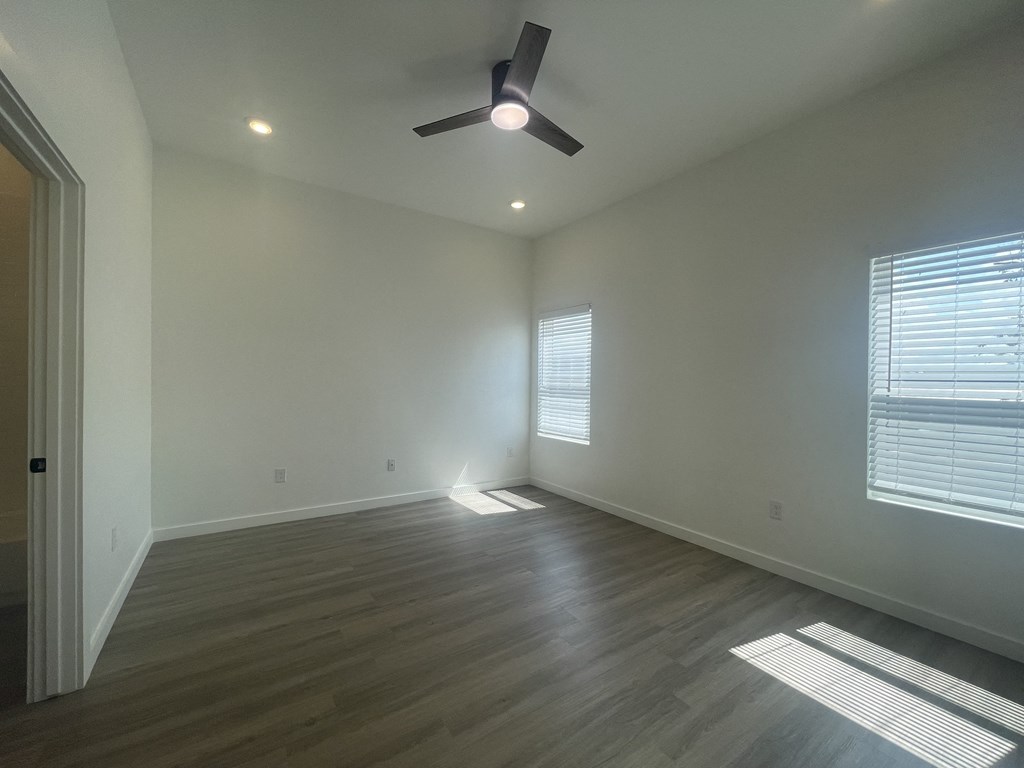 a living room with wood floors and a ceiling fan