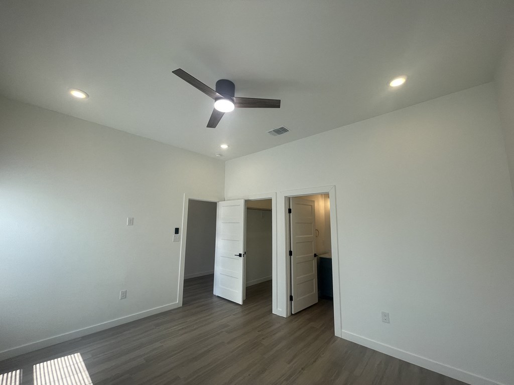 a living room with white walls and a ceiling fan