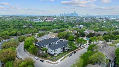 A residential area with houses and cars on the road.