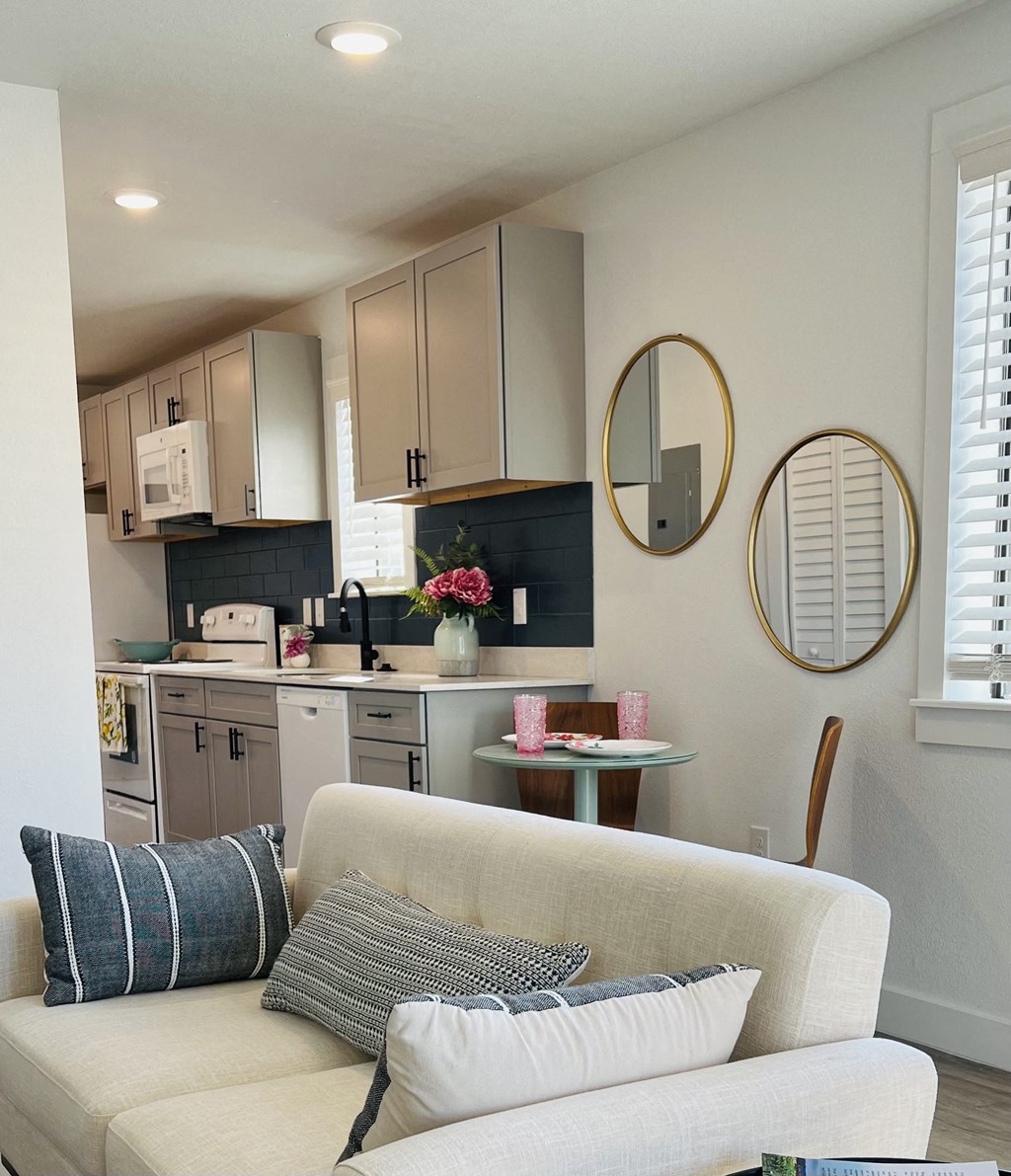 a living room with a couch and a kitchen