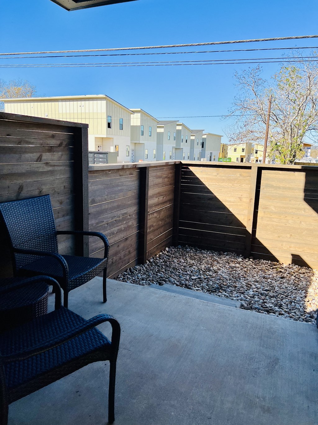 the patio has a privacy fence and chairs on it