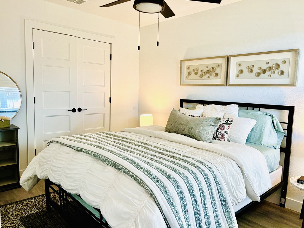 a bedroom with a bed with blue and white sheets and pillows