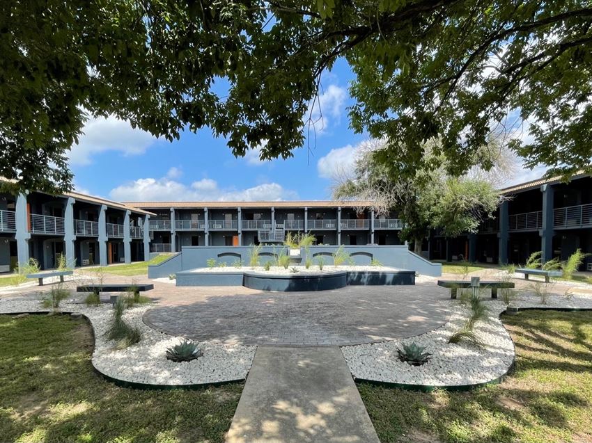 a courtyard with a fountain in front of a building