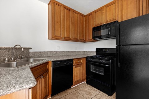 a kitchen with black appliances and wooden cabinets