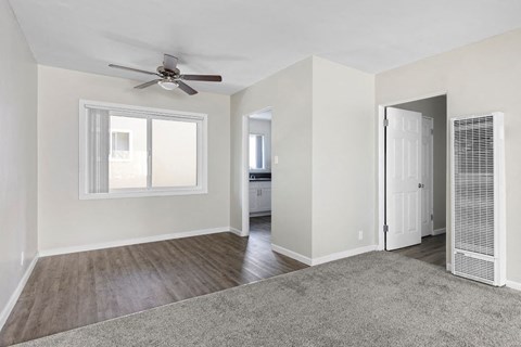 an empty living room with a ceiling fan