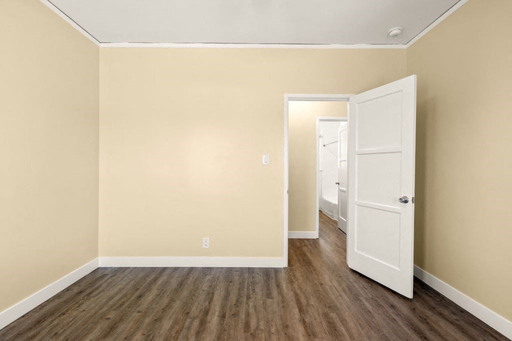 a empty room with wood floors and a white door
