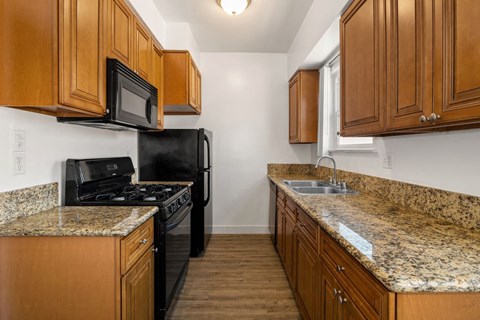 a kitchen with granite counter tops and black appliances
