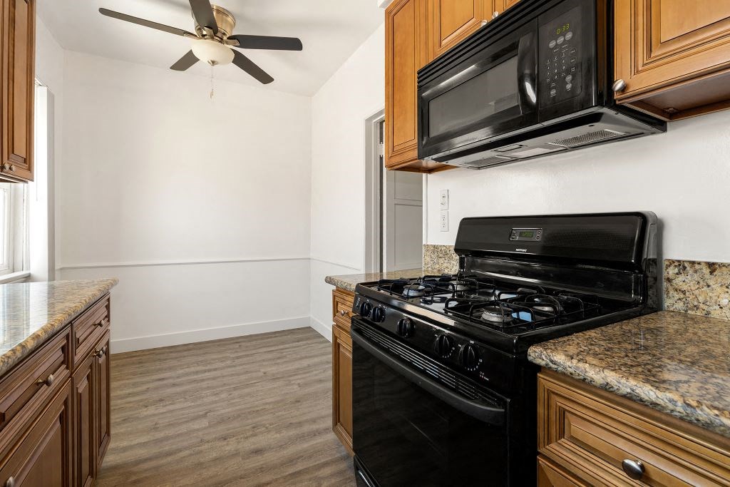 a kitchen with wooden cabinets and a black stove top oven