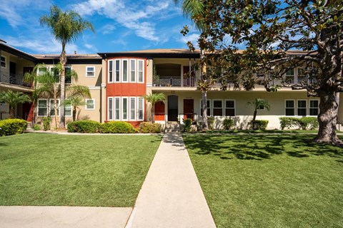 A building with a red door and a tree in front.