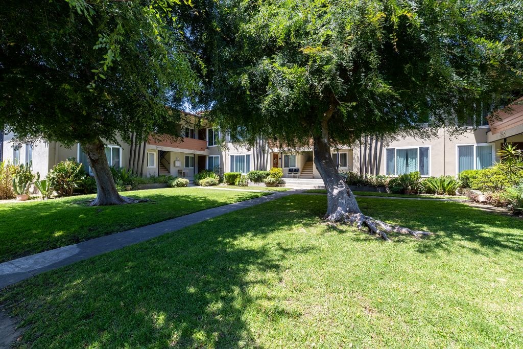 A tree-lined pathway leads to a building.