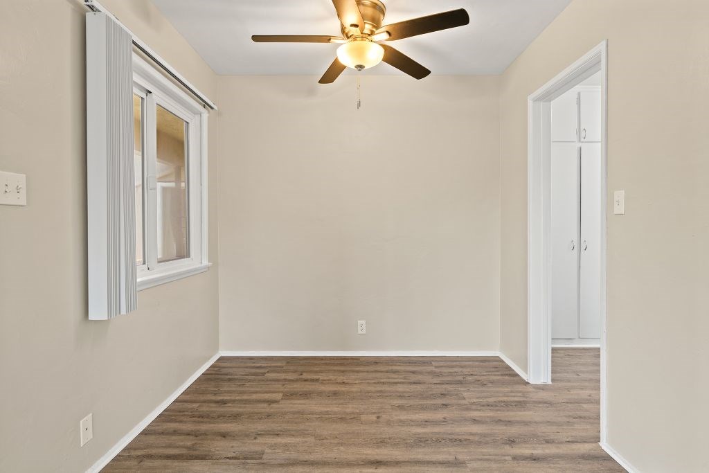 A room with a ceiling fan and a window.