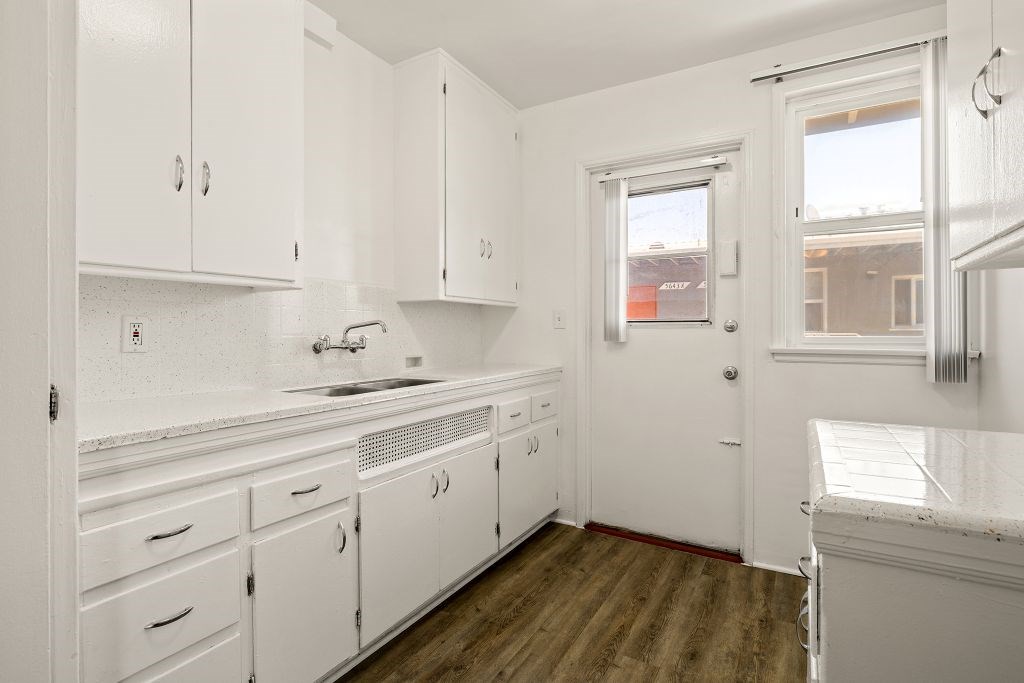 A kitchen with white cabinets and a window.