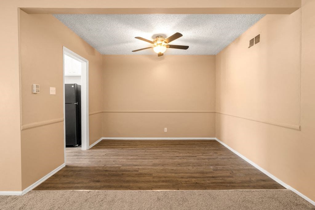 a empty room with a ceiling fan and a door