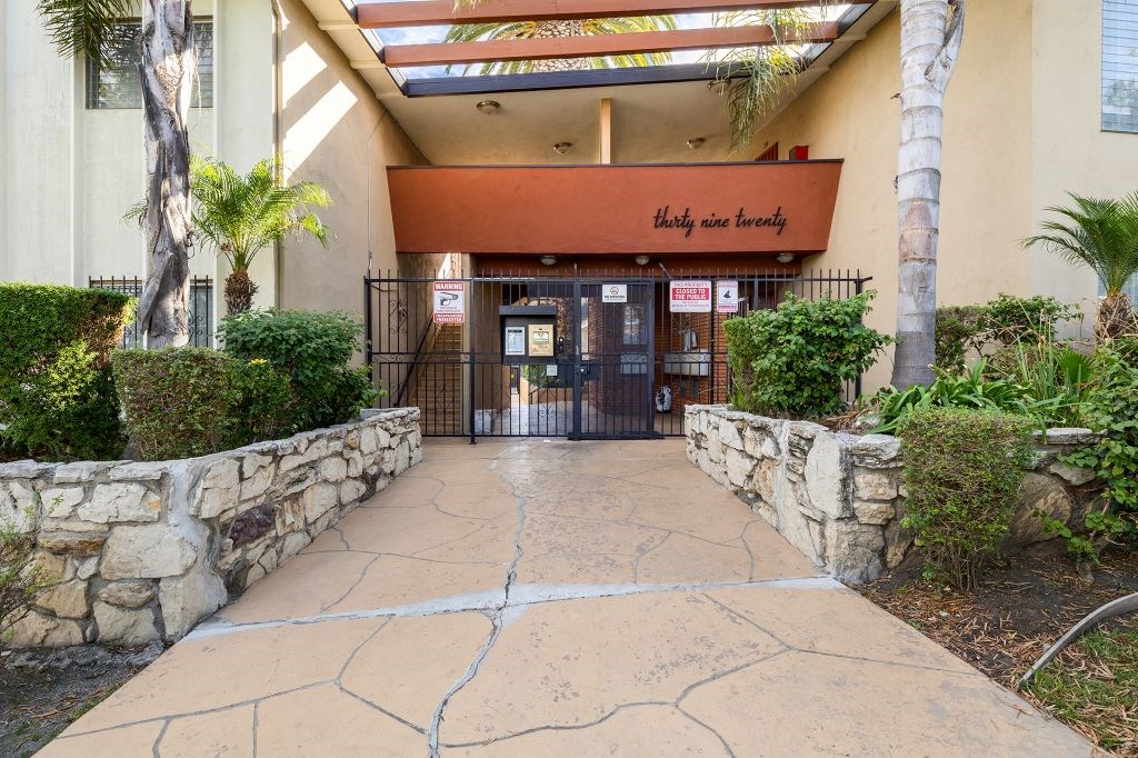 the entrance to a building with a stone walkway and a gate