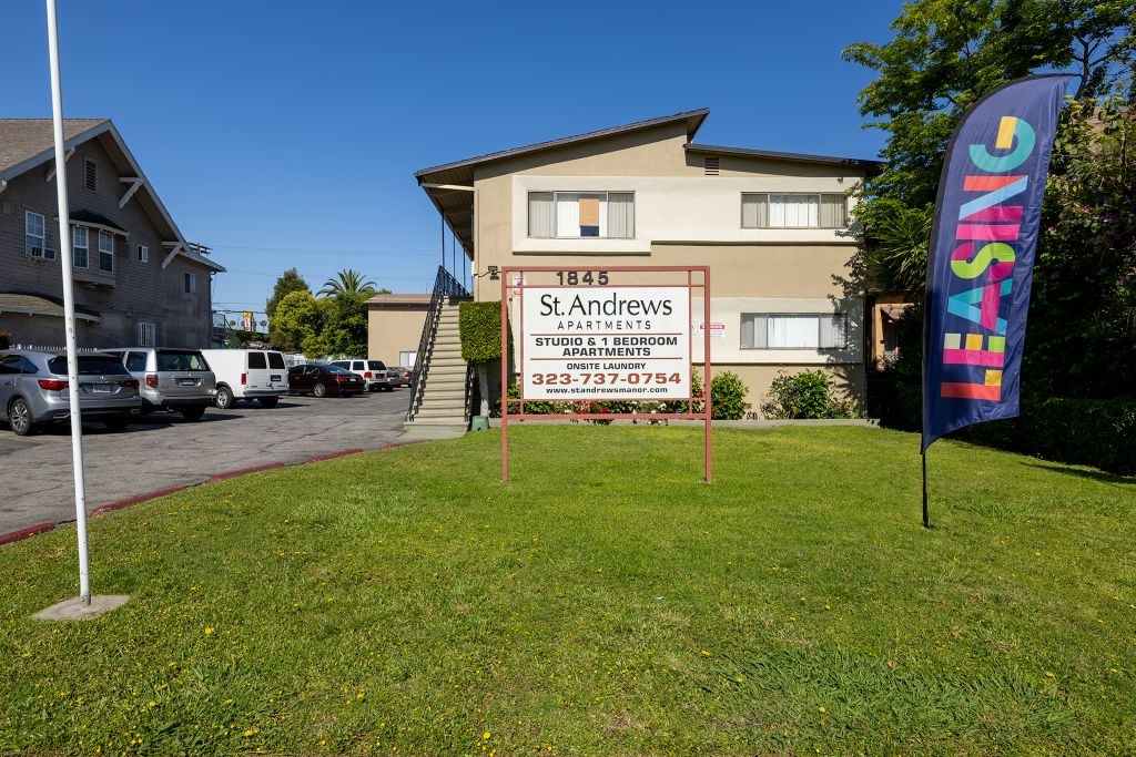 A sign for St. Andrews Student Apartments stands in front of a building.