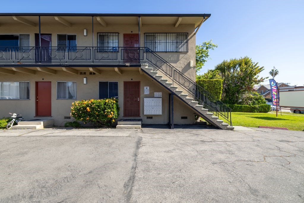 A building with a red door and a balcony with a metal railing.