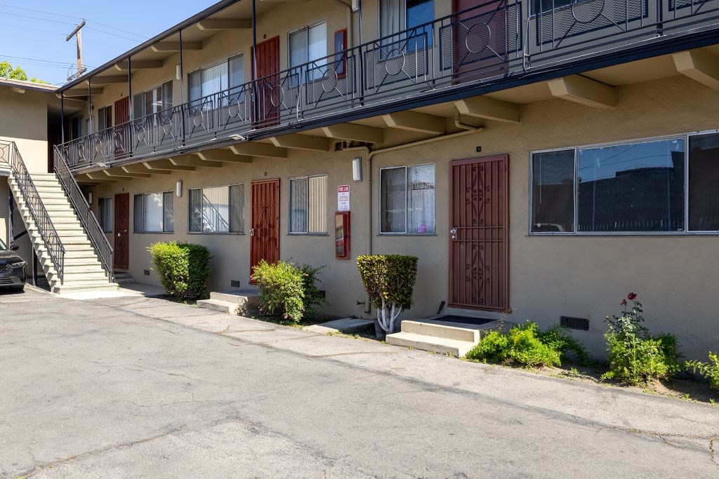 A building with a balcony and a red door.