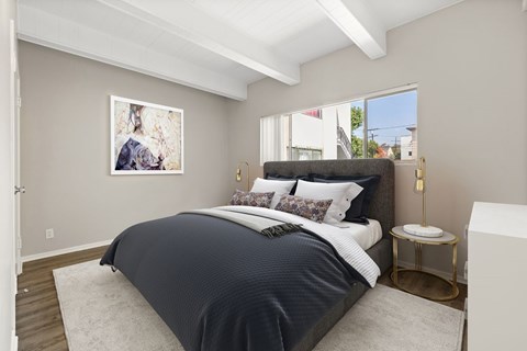 A bedroom with a large bed and a painting on the wall.