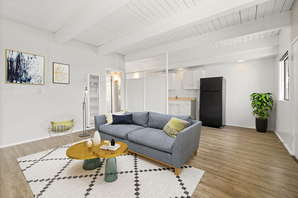 A living room with a grey couch, a coffee table, and a rug.
