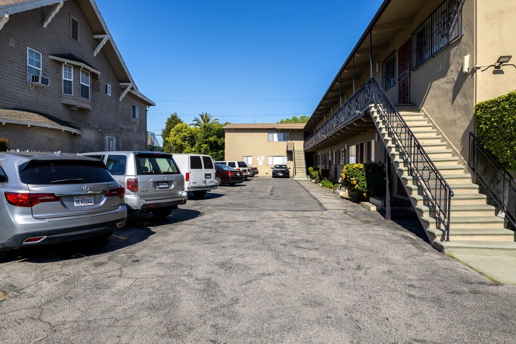 A parking lot with several cars and a building in the background.