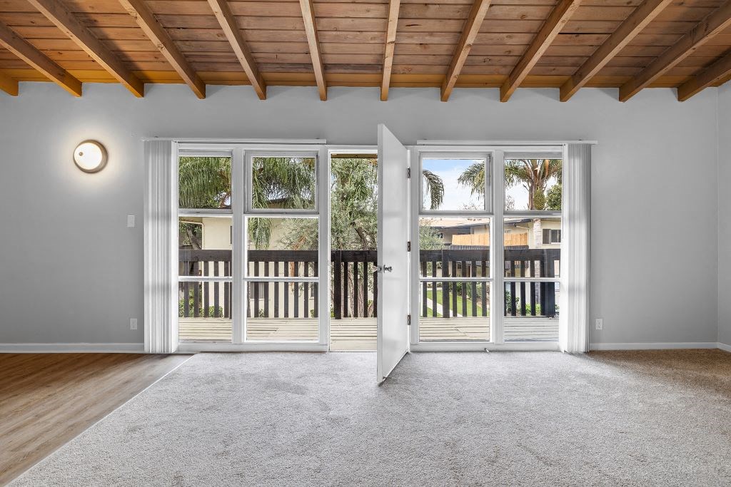 an empty living room with sliding glass doors to a balcony