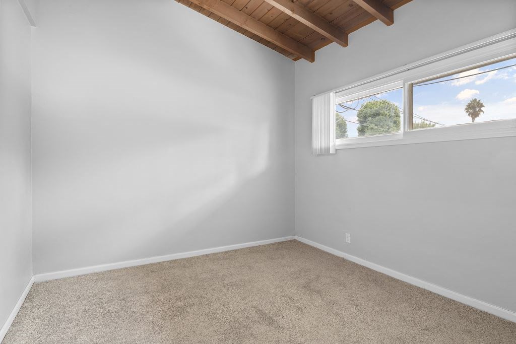 an empty room with a window and carpet