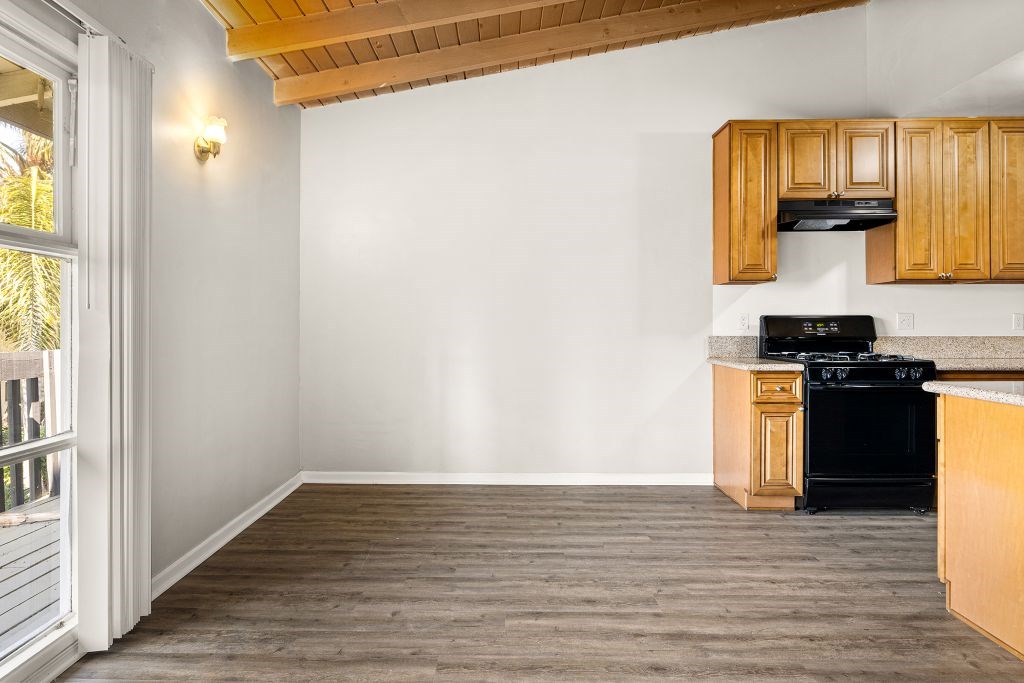 A kitchen with wooden cabinets and a black stove top oven.