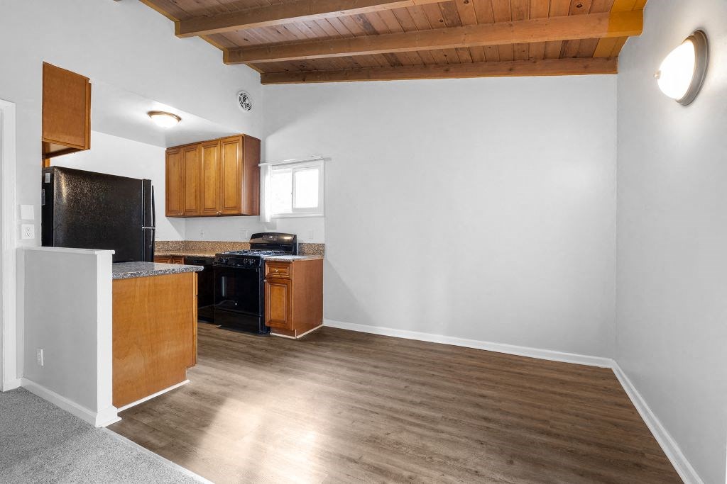 a kitchen with wooden floors and a black stove and refrigerator