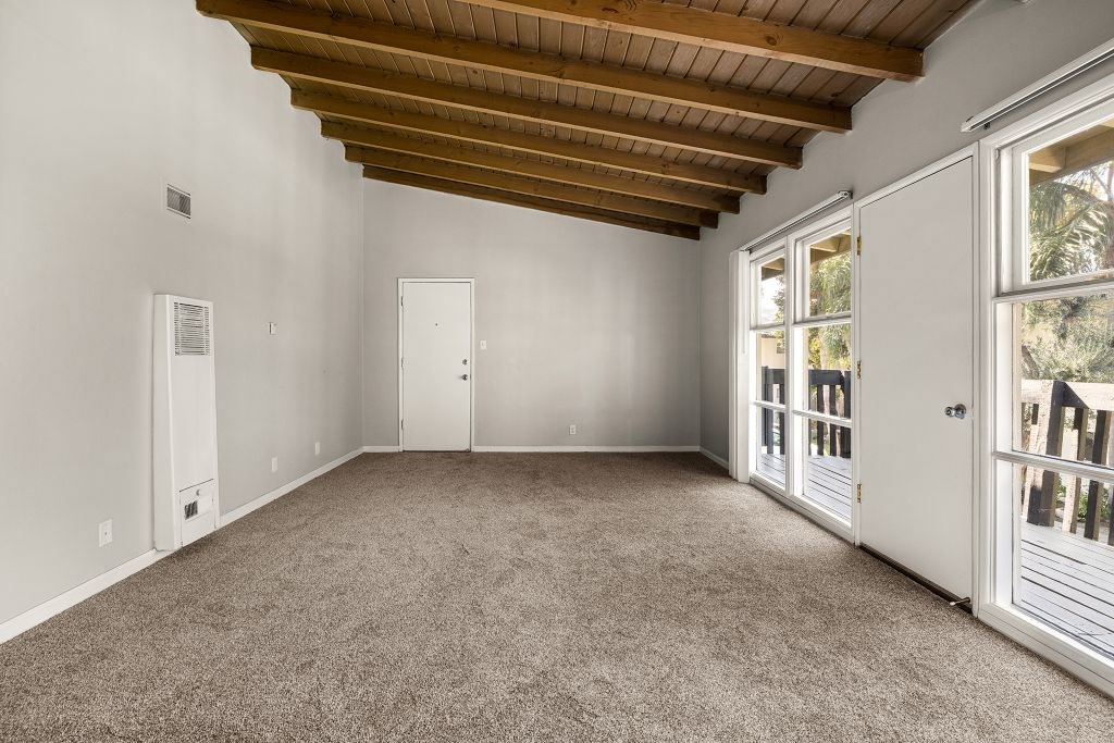 A room with a wooden ceiling and carpeted floor.