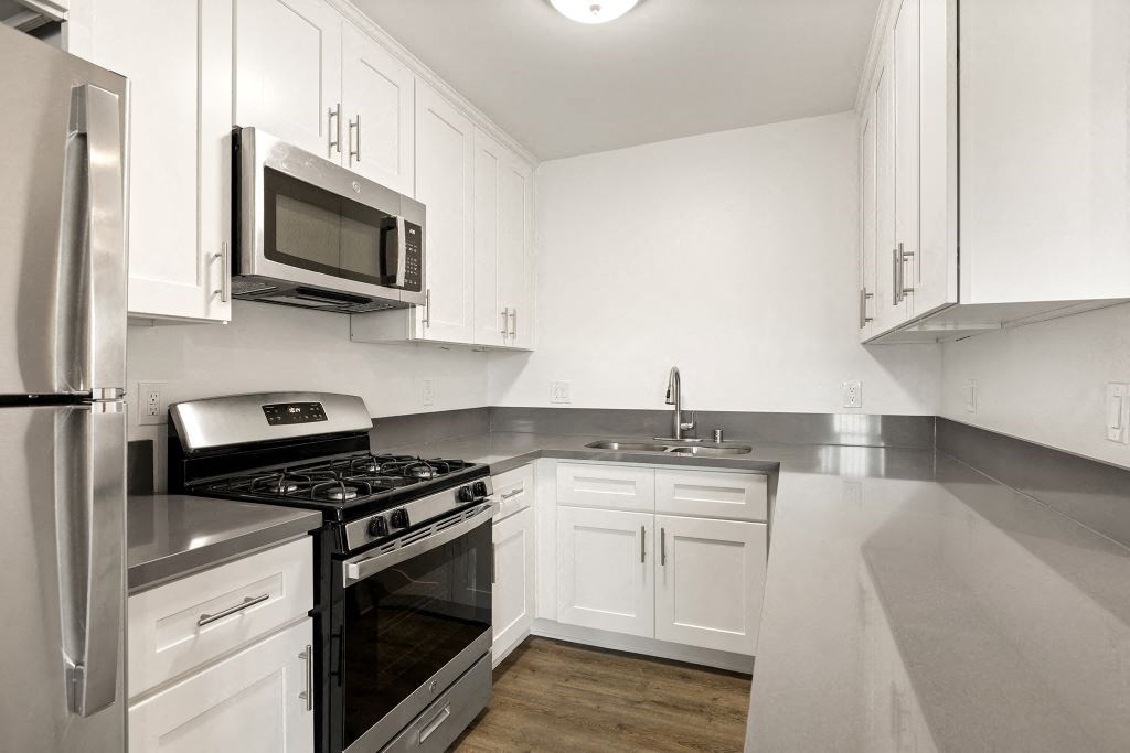 a kitchen with stainless steel appliances and white cabinets
