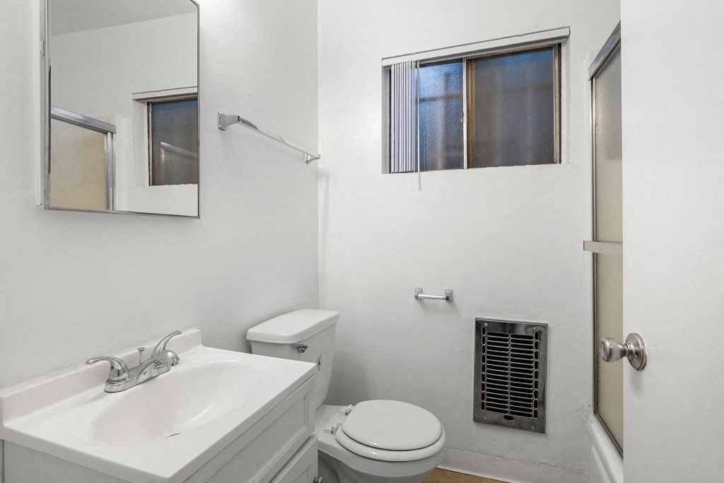 a bathroom with a sink toilet and mirror