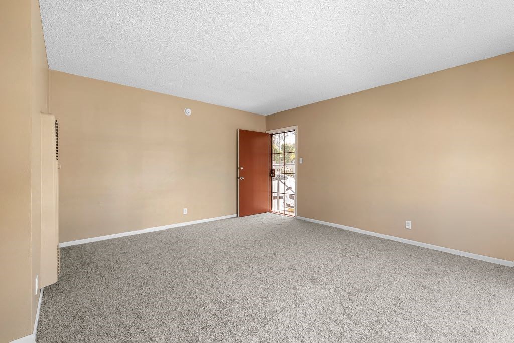 an empty bedroom with a door leading to a patio