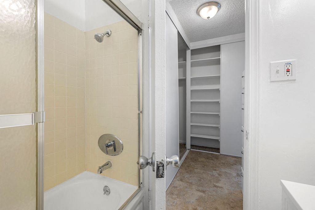 a bathroom with a bathtub and a walk in closet