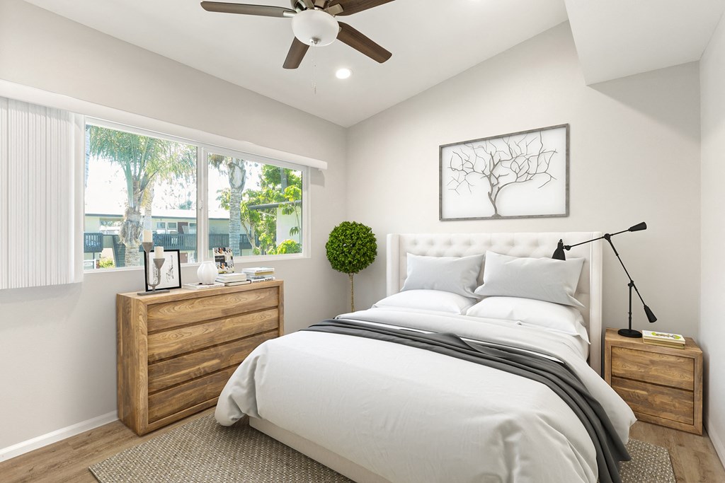 a white bedroom with a large bed and a ceiling fan