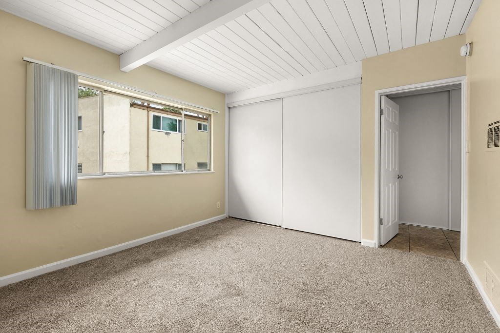 a bedroom with beige walls and a white ceiling