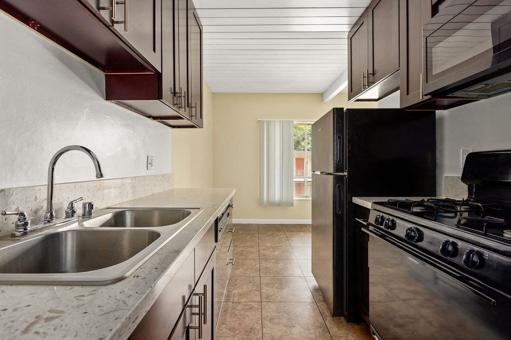 a kitchen with a sink a stove and a refrigerator