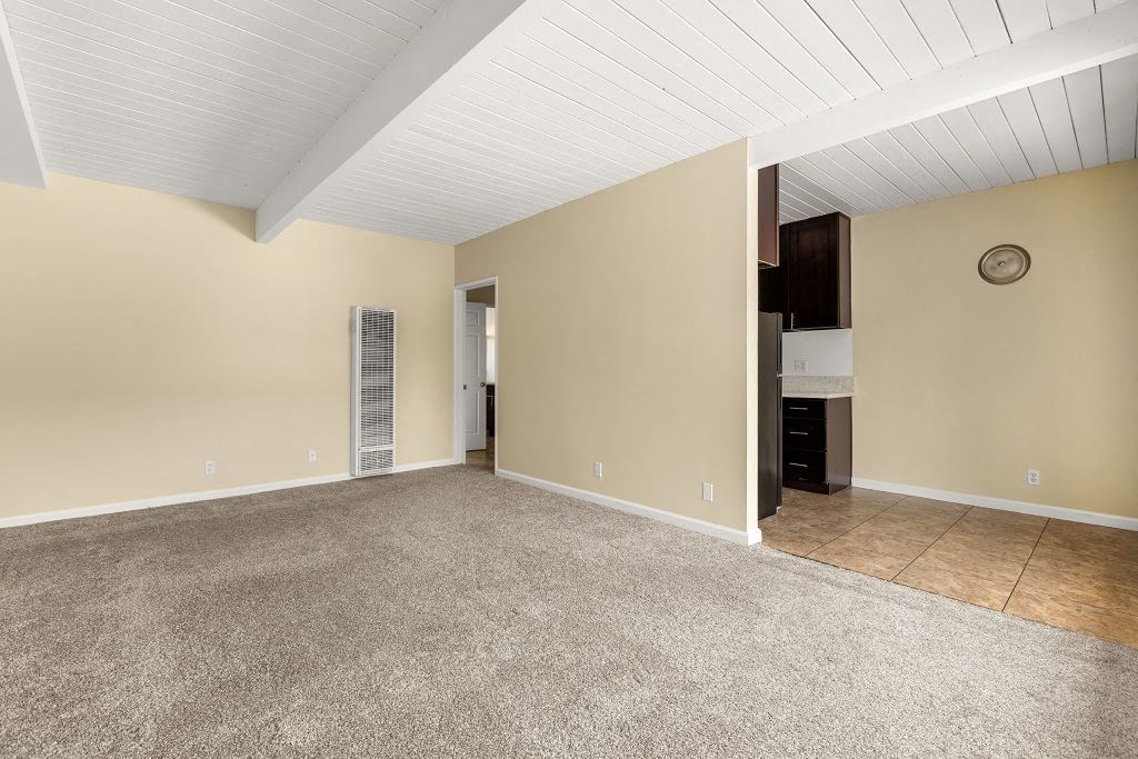 a living room with beige walls and a beige carpet