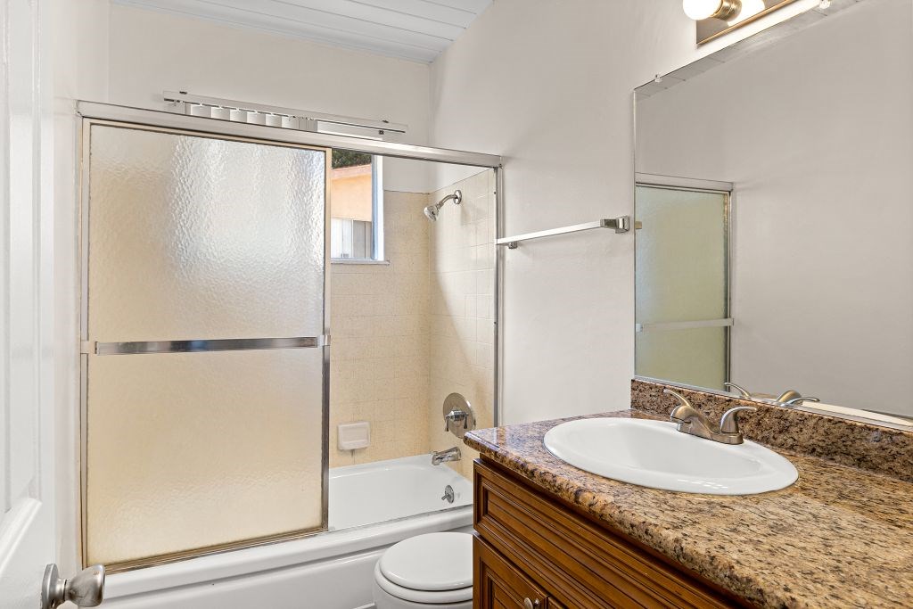A bathroom with a sink, toilet, and shower.