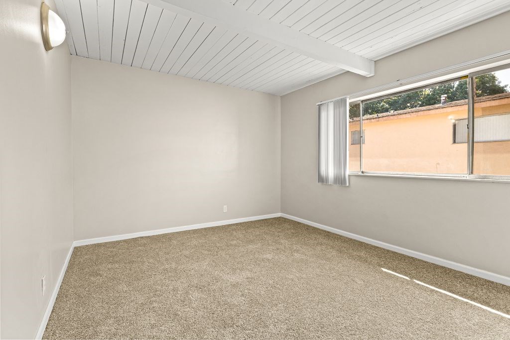 Empty room with carpeted floor and a window.