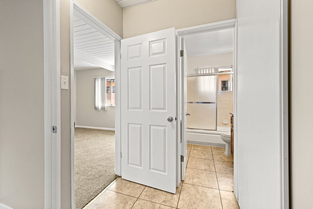 A white door is open to a kitchen.