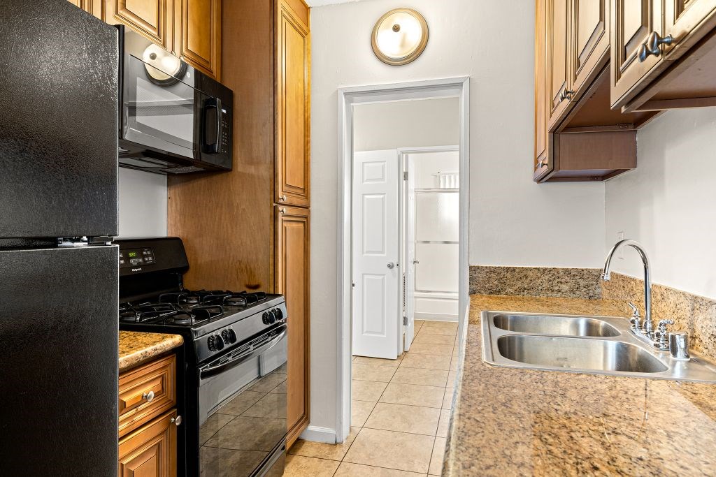 A kitchen with a black fridge, microwave, and stove.