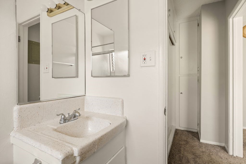 A bathroom with a sink and mirror.