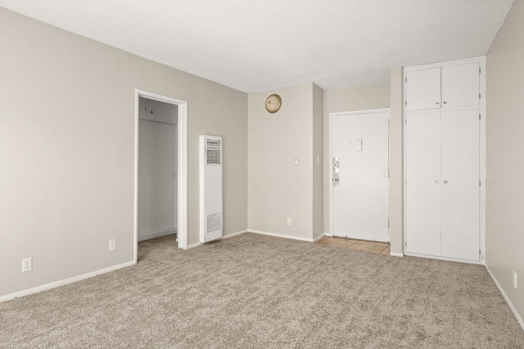 A room with a carpeted floor and white walls.