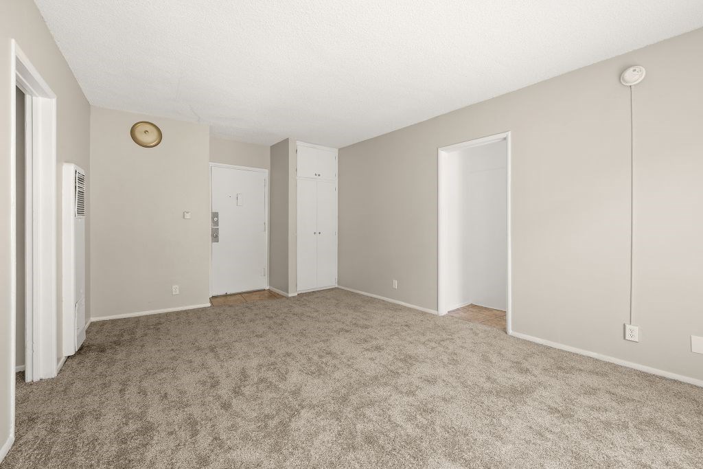 A room with carpeted floor and white walls.