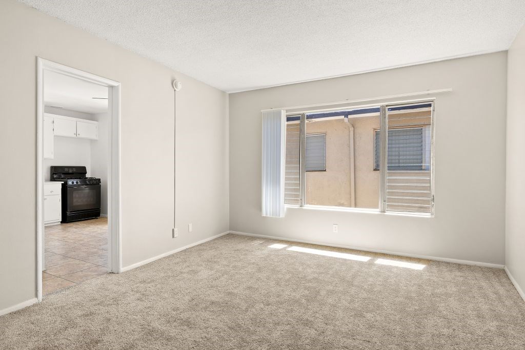 A room with a window and a door leading to another room.