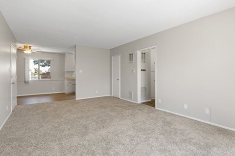 A spacious, empty room with a carpeted floor and white walls.