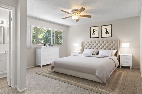 A bedroom with a large bed, a dresser, and a ceiling fan.