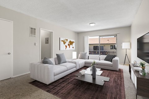 A living room with a white couch and a world map on the wall.