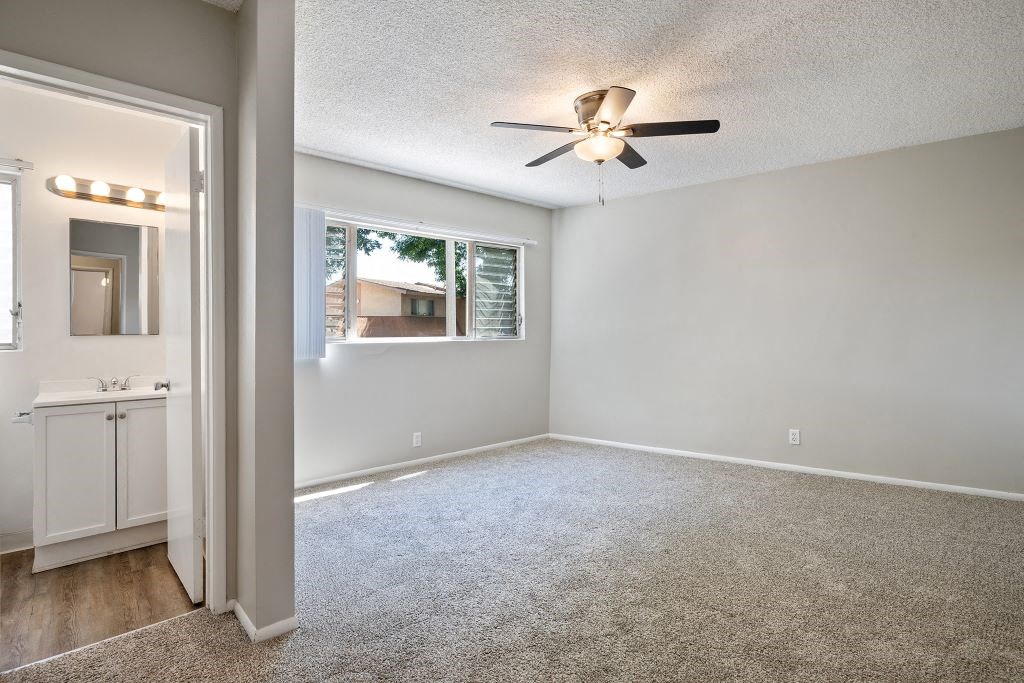 an empty bedroom with a ceiling fan