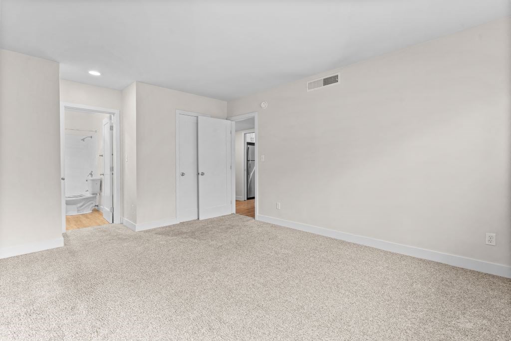 an empty living room with white walls and a carpeted floor